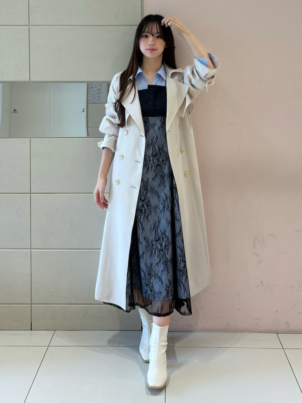 ブルー系のワンピース、ホワイト系のトレンチコート、ホワイト系のブーツを着用したレディースの冬コーディネートの3枚目の写真