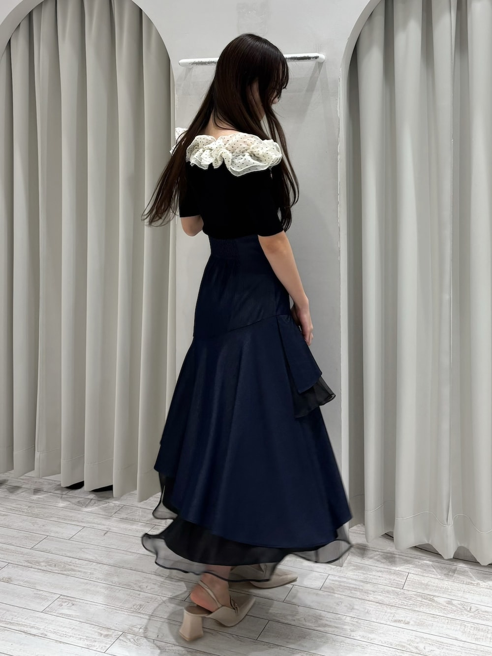 ブルー系のスカート、その他のニット/セーター、ホワイト系のパンプスを着用したレディースの春コーディネートの5枚目の写真