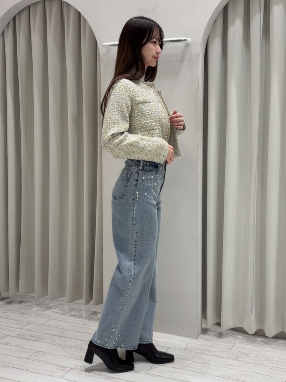 ブラウン系のブーツ、ホワイト系のニット/セーター、グリーン系のテーラードジャケットを着用したレディースの冬コーディネートの3枚目の写真