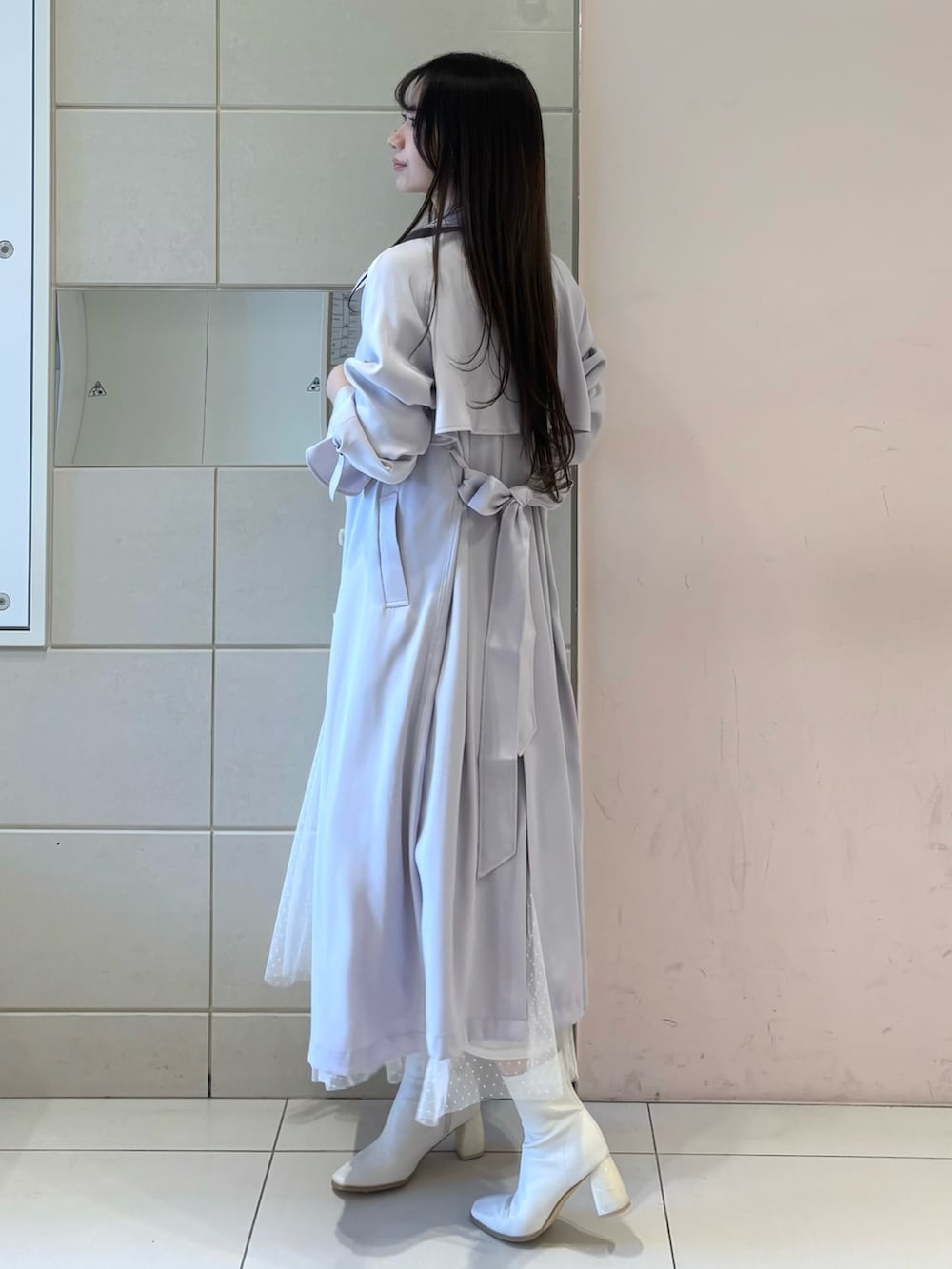 ホワイト系のワンピース、パープル系のトレンチコート、ホワイト系のブーツを着用したレディースの冬コーディネートの3枚目の写真