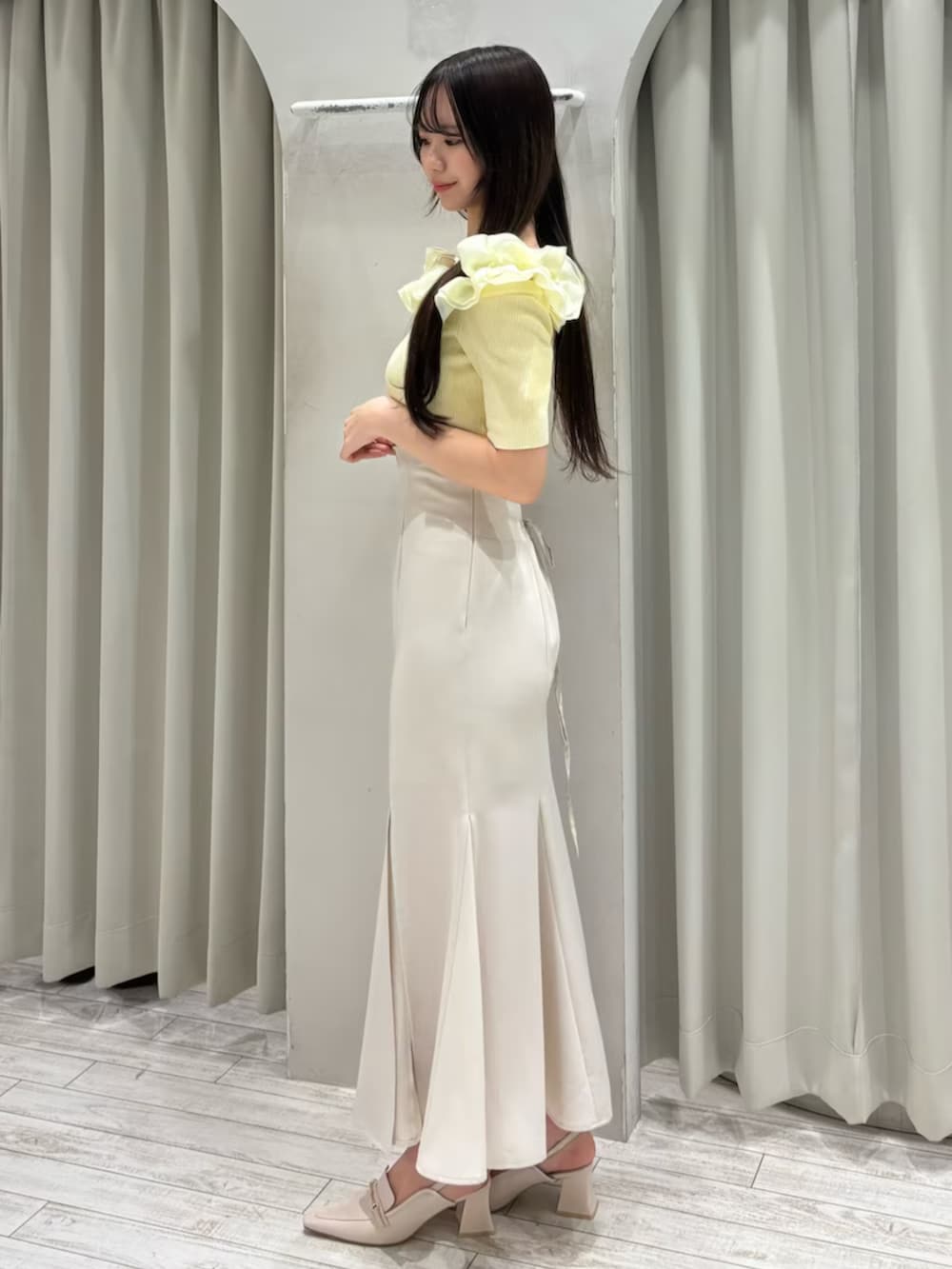 ホワイト系のスカート、ホワイト系のパンプス、イエロー系のニット/セーターを着用したレディースの春コーディネートの3枚目の写真