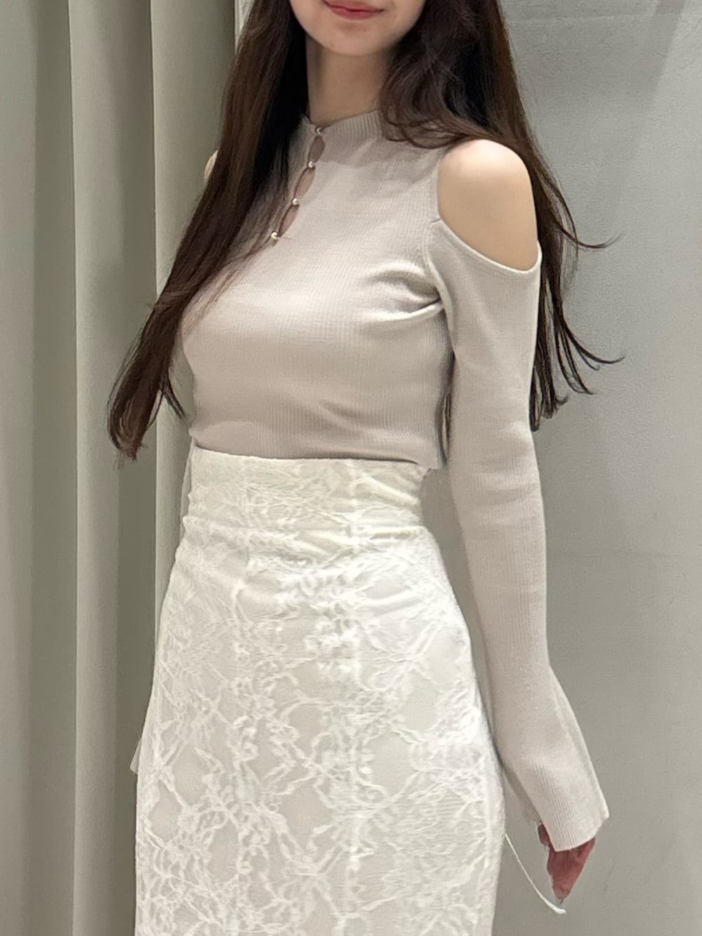 ベージュ系のニット/セーター、ホワイト系のスカート、ホワイト系のブーツを着用したレディースの春コーディネートの9枚目の写真