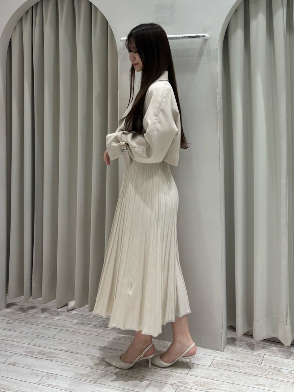 ブラウン系のハンドバッグ、ホワイト系のパンプス、ベージュ系のトレンチコートを着用したレディースの春コーディネートの4枚目の写真