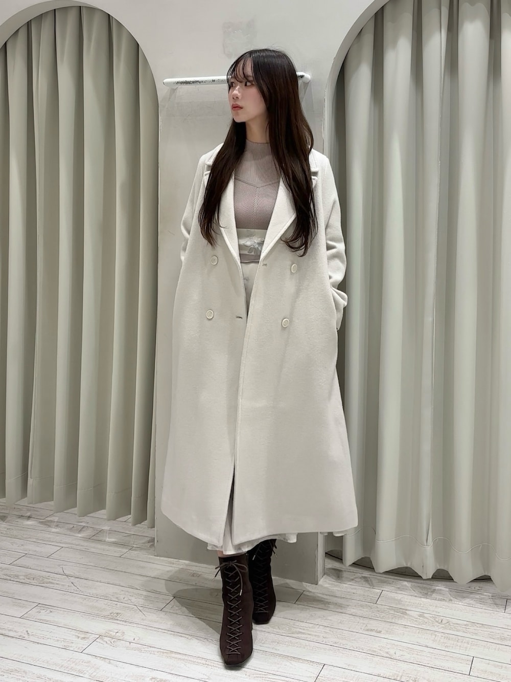 ベージュ系のワンピース、ホワイト系のショルダーバッグ、ホワイト系のチェスターコートを着用したレディースの秋コーディネートの2枚目の写真