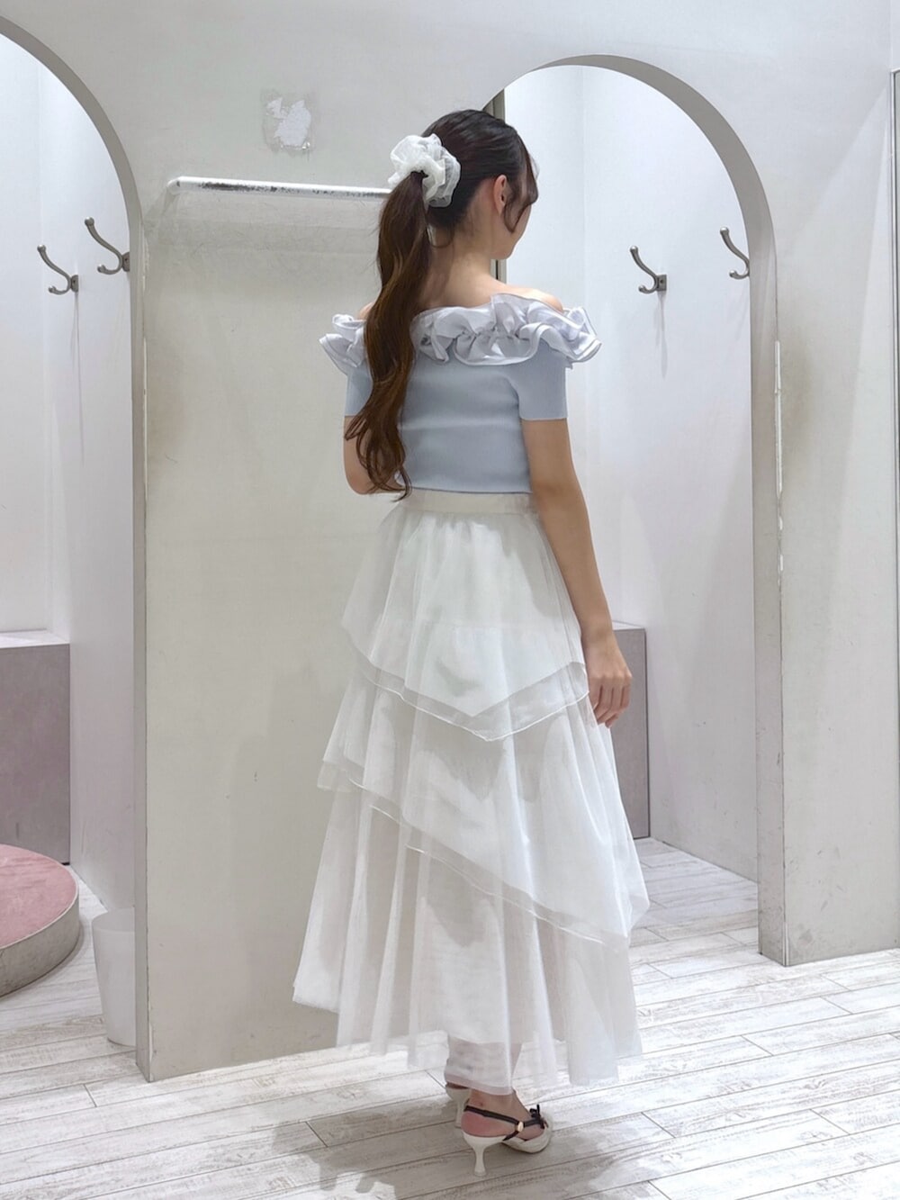 ブルー系のニット/セーター、ホワイト系のサンダル、ホワイト系のスカートを着用したレディースの夏コーディネートの6枚目の写真
