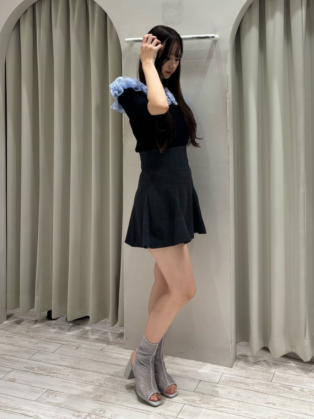 ブルー系のニット/セーター、グレー系のスカート、グレー系のブーツを着用したレディースの春コーディネートの3枚目の写真