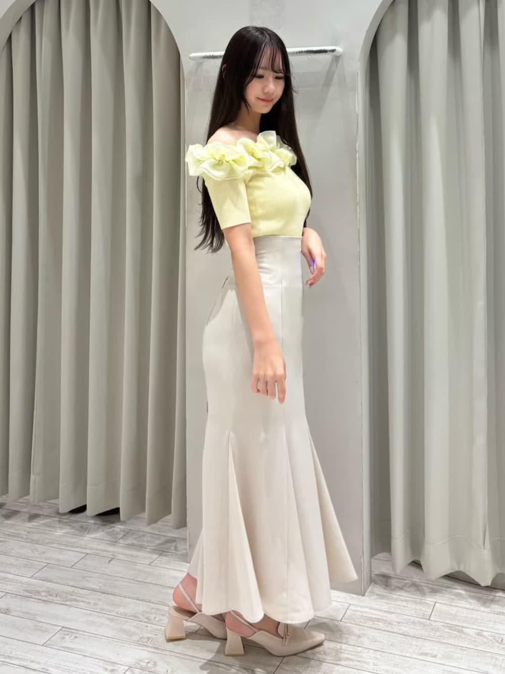 ホワイト系のスカート、ホワイト系のパンプス、イエロー系のニット/セーターを着用したレディースの春コーディネートの4枚目の写真