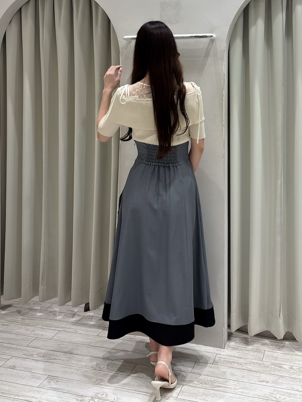 ホワイト系のニット/セーター、グレー系のスカート、ホワイト系のパンプスを着用したレディースの春コーディネートの4枚目の写真