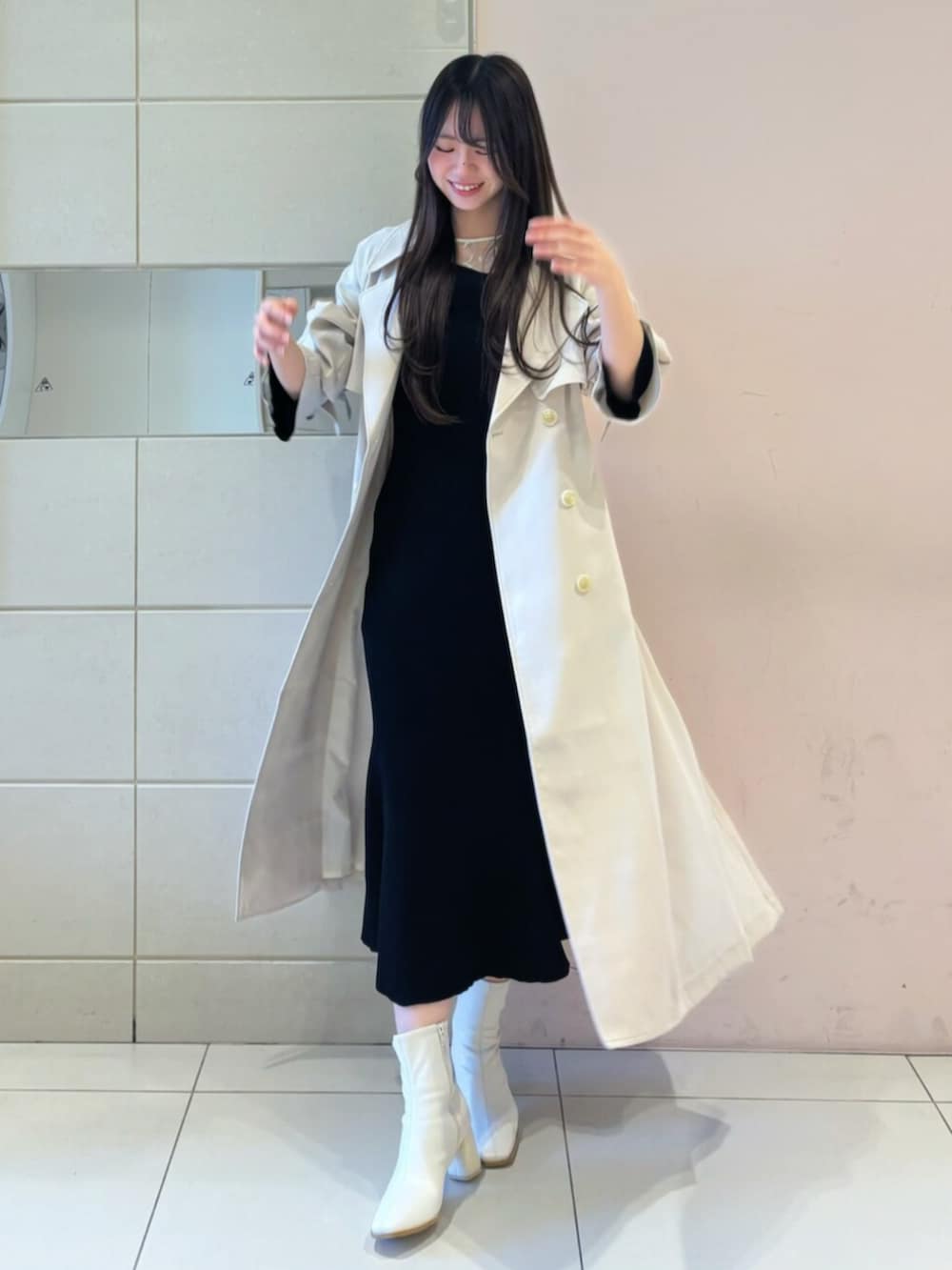 ホワイト系のブーツ、ブラック系のワンピース、ホワイト系のトレンチコートを着用したレディースの冬コーディネートの3枚目の写真