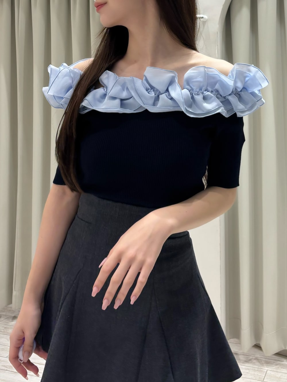 ブルー系のニット/セーター、グレー系のスカート、グレー系のブーツを着用したレディースの春コーディネートの5枚目の写真