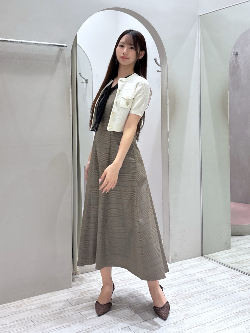 ホワイト系のカーディガン/ボレロ、ブラウン系のワンピース、ブラウン系のパンプスを着用したレディースの夏コーディネートの6枚目の写真