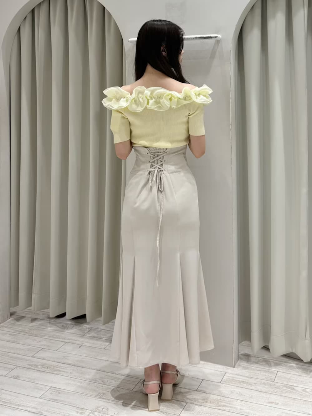 ホワイト系のスカート、ホワイト系のパンプス、イエロー系のニット/セーターを着用したレディースの春コーディネートの5枚目の写真