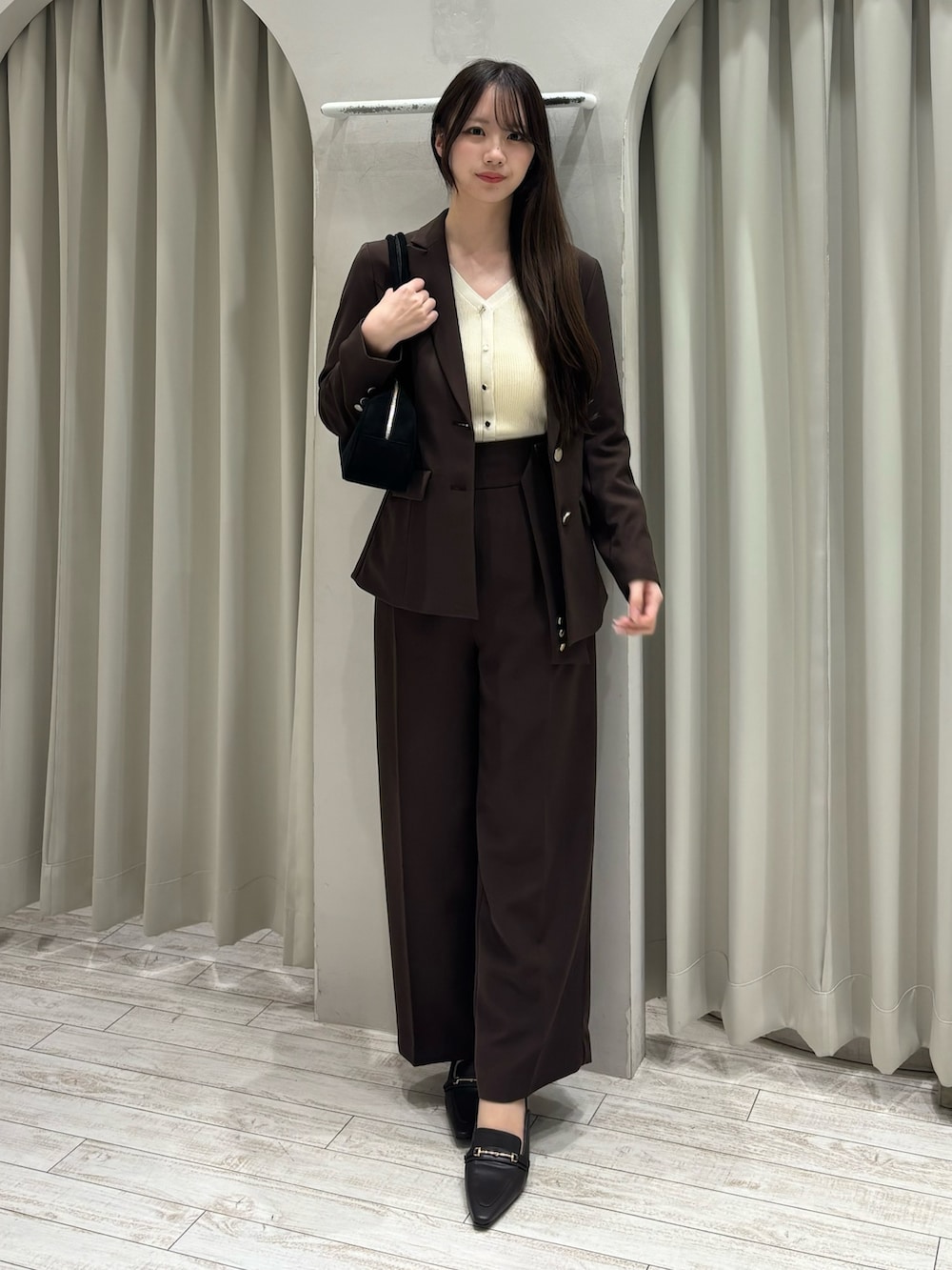 ブラウン系のテーラードジャケット、ホワイト系のニット/セーター、ブラウン系のその他パンツを着用したレディースの春コーディネートの2枚目の写真