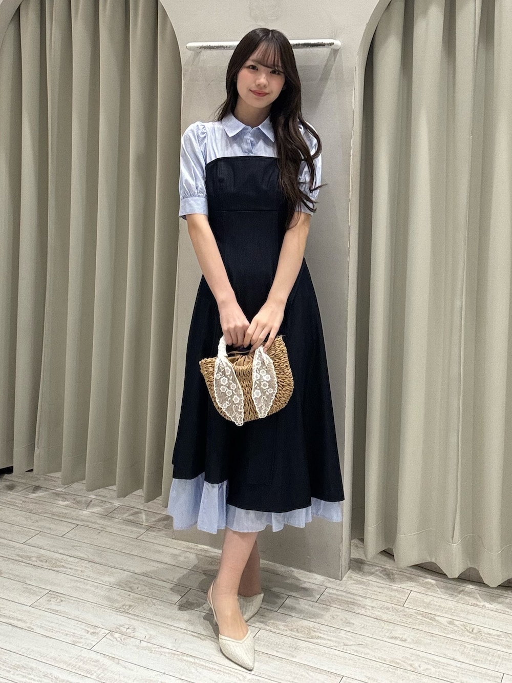 ブルー系のワンピース、ベージュ系のハンドバッグ、ホワイト系のパンプスを着用したレディースの春コーディネートの6枚目の写真