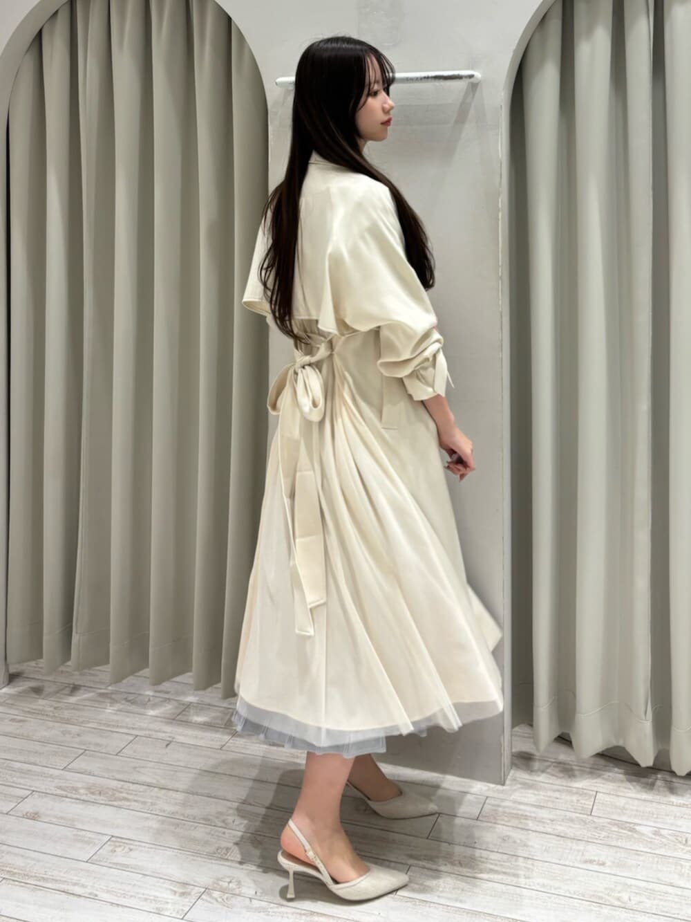 ホワイト系のパンプス、グレー系のワンピース、ホワイト系のトレンチコートを着用したレディースの春コーディネートの3枚目の写真