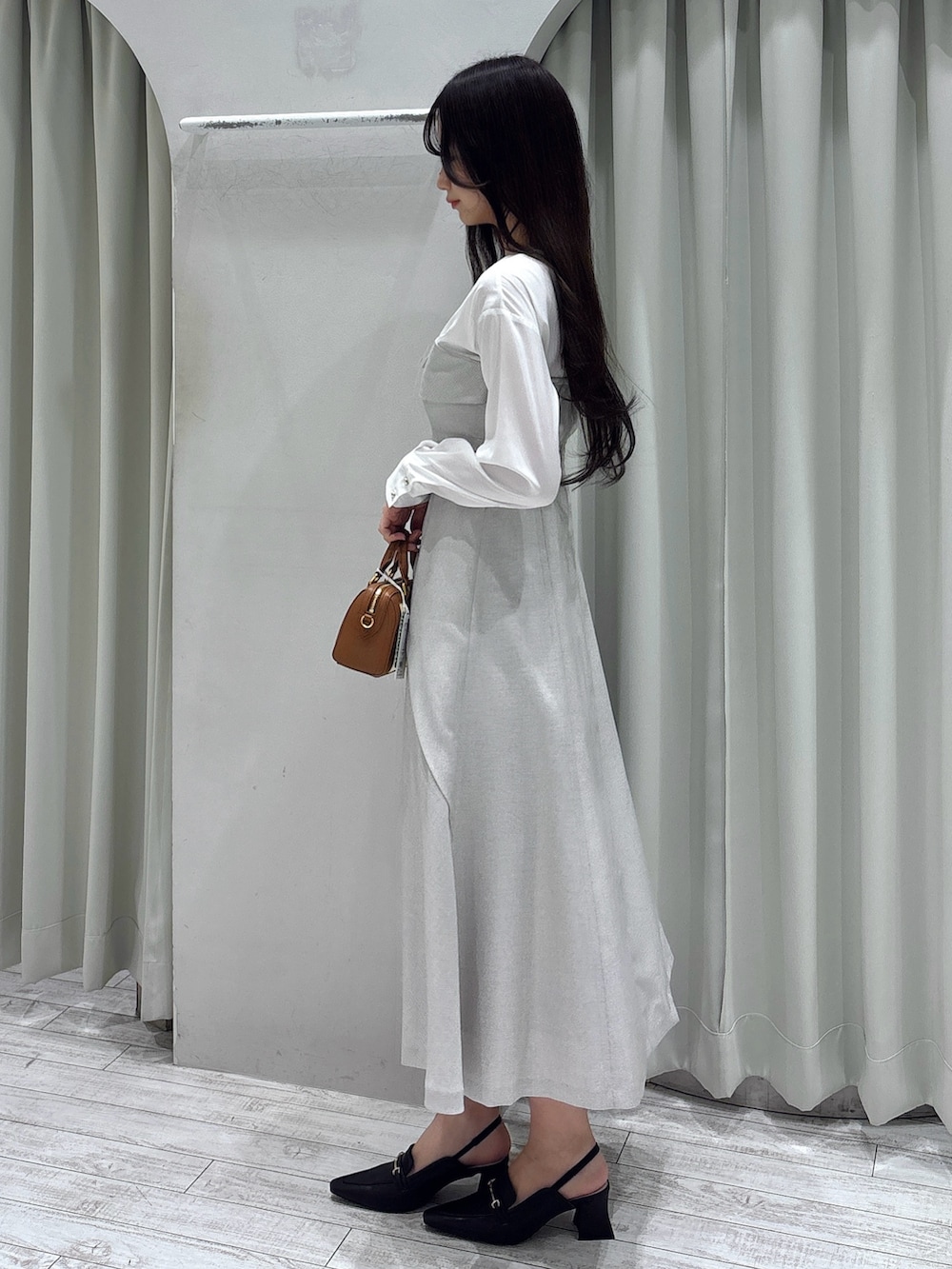 ベージュ系のワンピース、ブラウン系のハンドバッグ、ブラウン系のパンプスを着用したレディースの春コーディネートの4枚目の写真