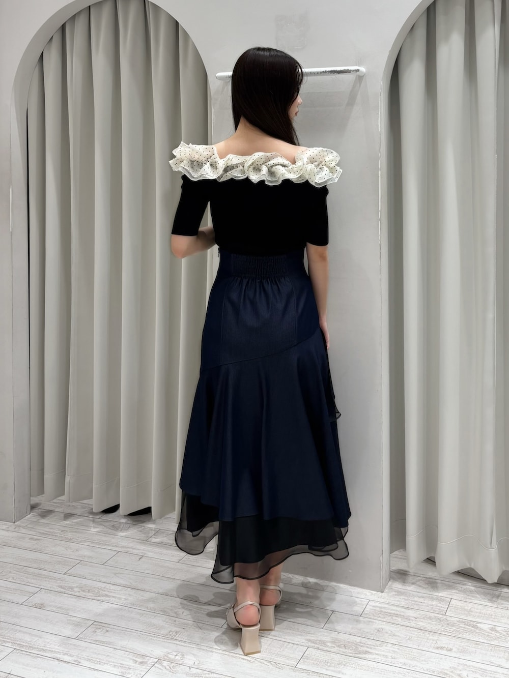 ブルー系のスカート、その他のニット/セーター、ホワイト系のパンプスを着用したレディースの春コーディネートの6枚目の写真