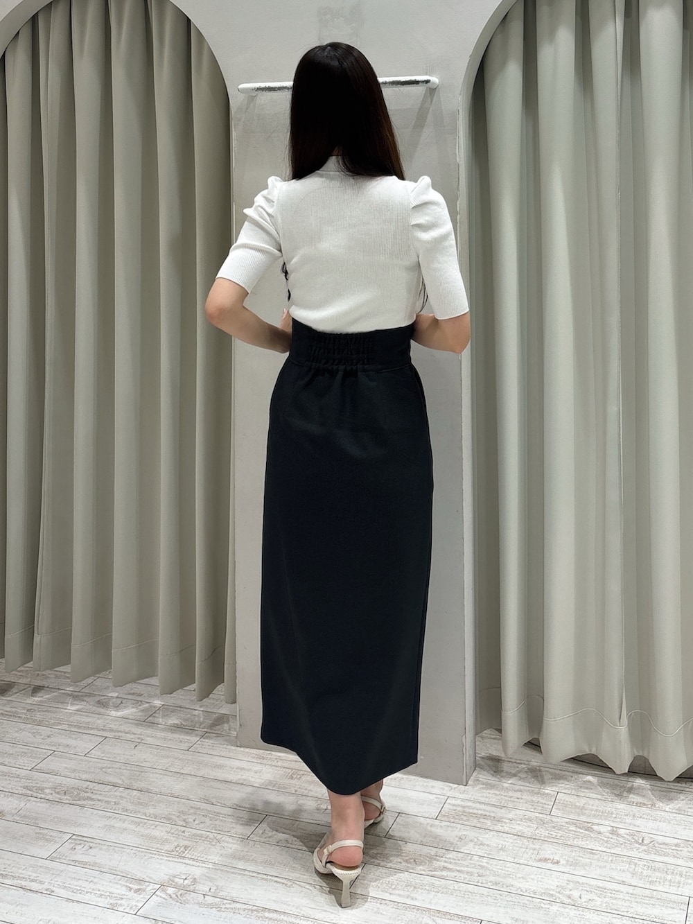 グレー系のスカート、ホワイト系のニット/セーター、ホワイト系のパンプスを着用したレディースの春コーディネートの4枚目の写真