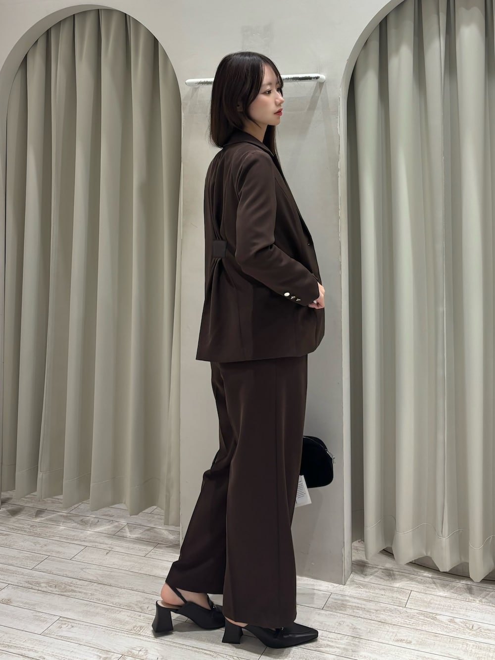 ブラウン系のテーラードジャケット、ホワイト系のニット/セーター、ブラウン系のその他パンツを着用したレディースの春コーディネートの5枚目の写真