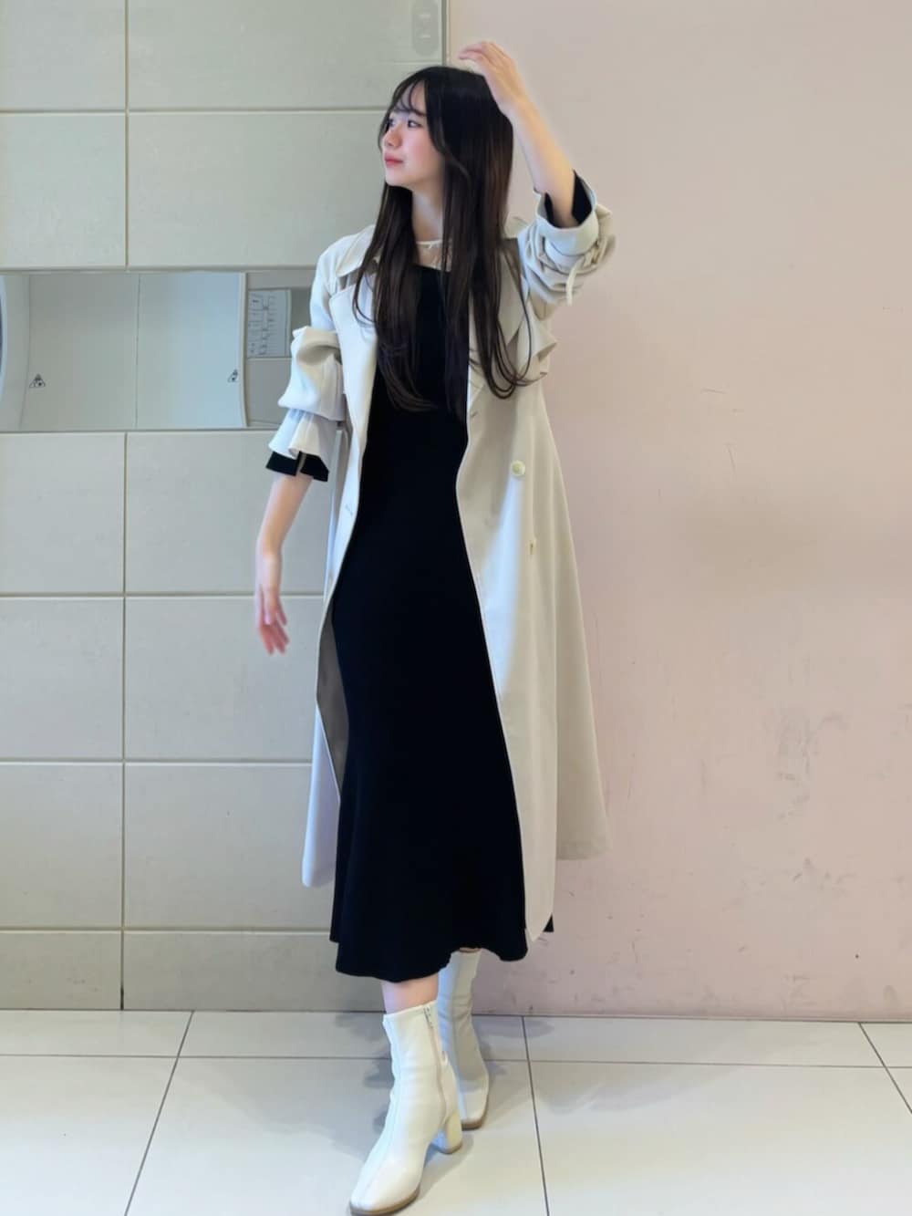 ホワイト系のブーツ、ブラック系のワンピース、ホワイト系のトレンチコートを着用したレディースの冬コーディネートの4枚目の写真