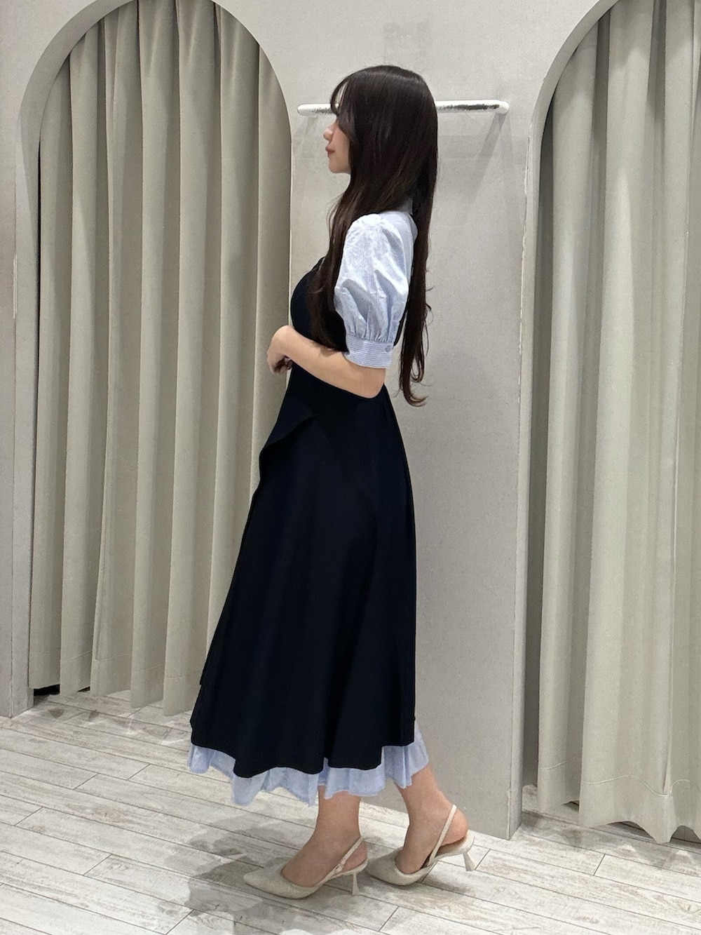 ブルー系のワンピース、ベージュ系のハンドバッグ、ホワイト系のパンプスを着用したレディースの春コーディネートの3枚目の写真