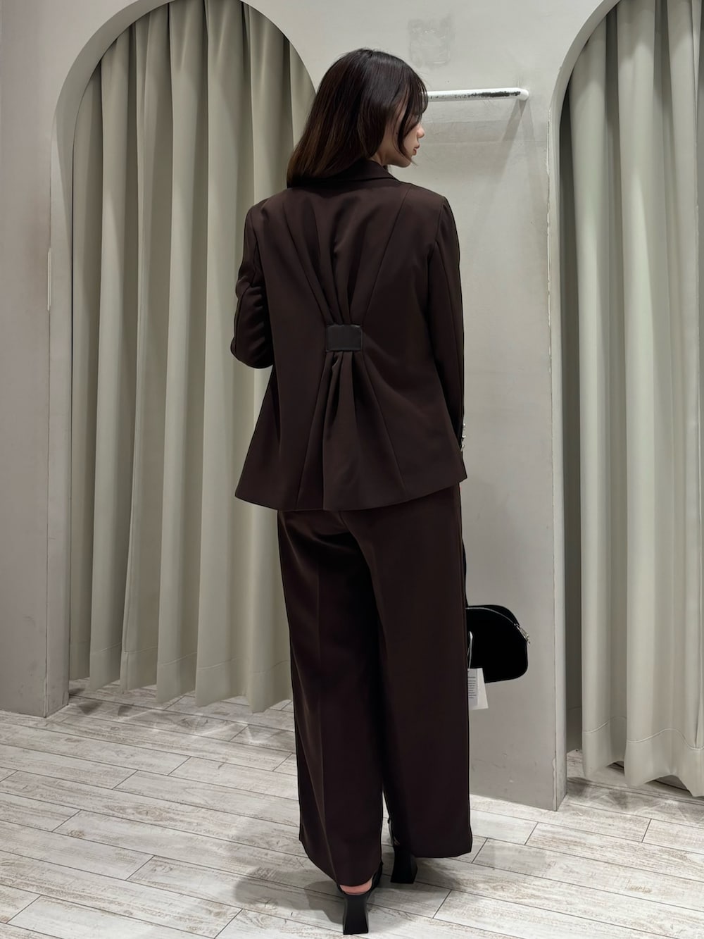 ブラウン系のテーラードジャケット、ホワイト系のニット/セーター、ブラウン系のその他パンツを着用したレディースの春コーディネートの4枚目の写真