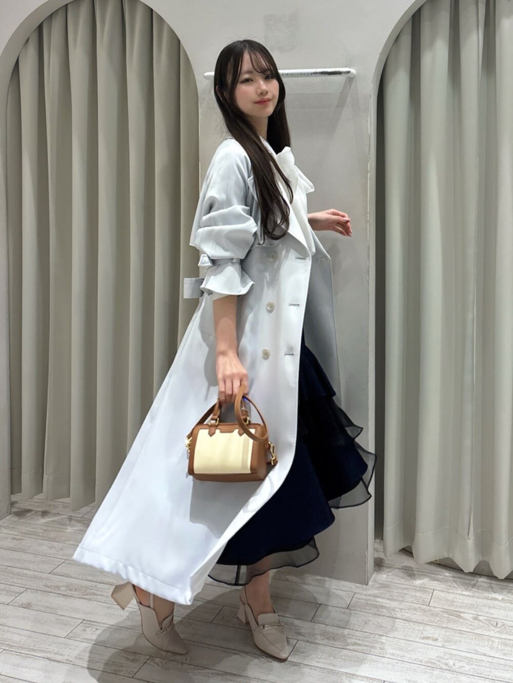 ホワイト系のパンプス、ホワイト系のシャツ/ブラウス、ブラウン系のハンドバッグを着用したレディースの春コーディネートの4枚目の写真