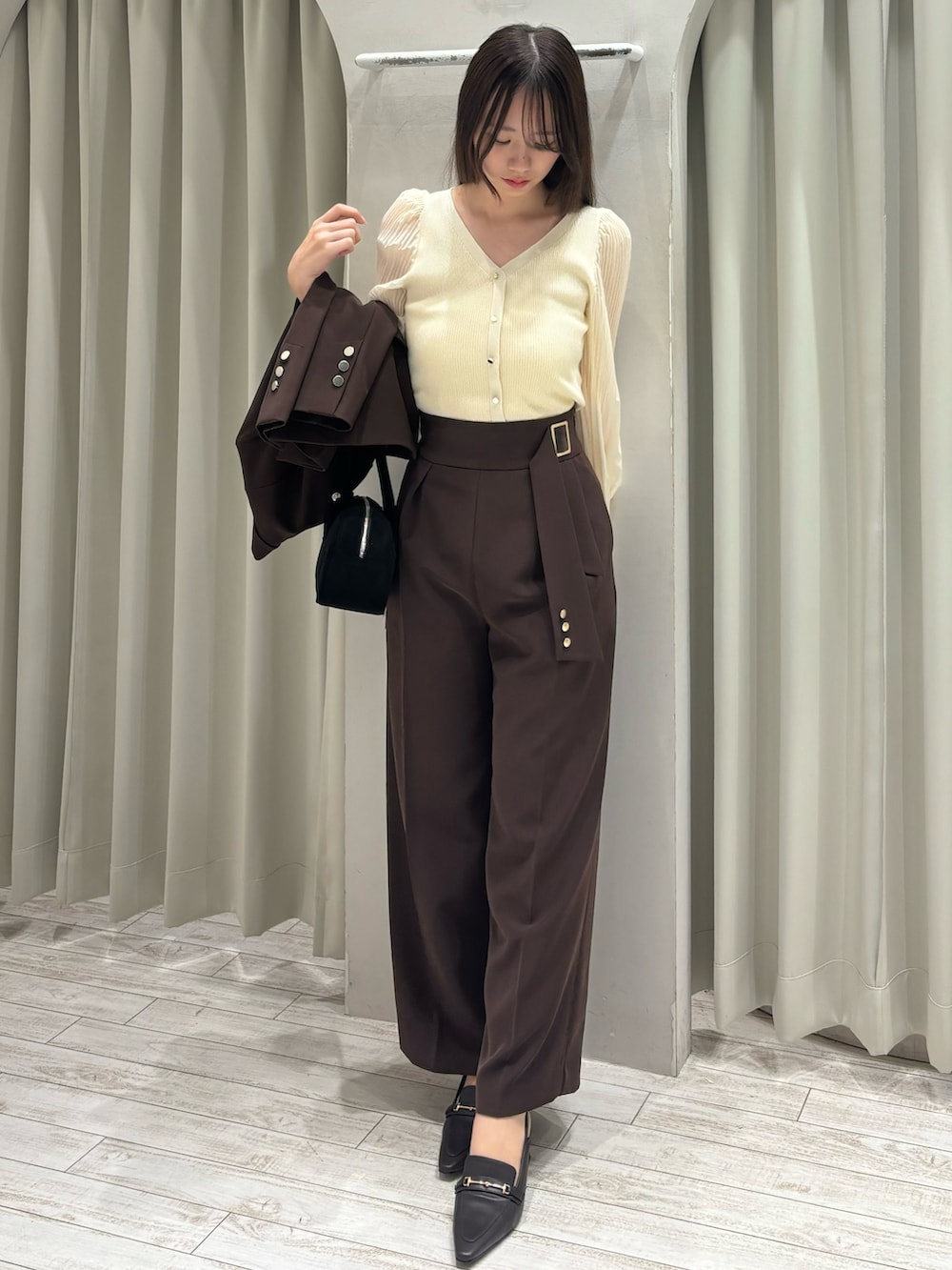 ブラウン系のテーラードジャケット、ホワイト系のニット/セーター、ブラウン系のその他パンツを着用したレディースの春コーディネートの6枚目の写真