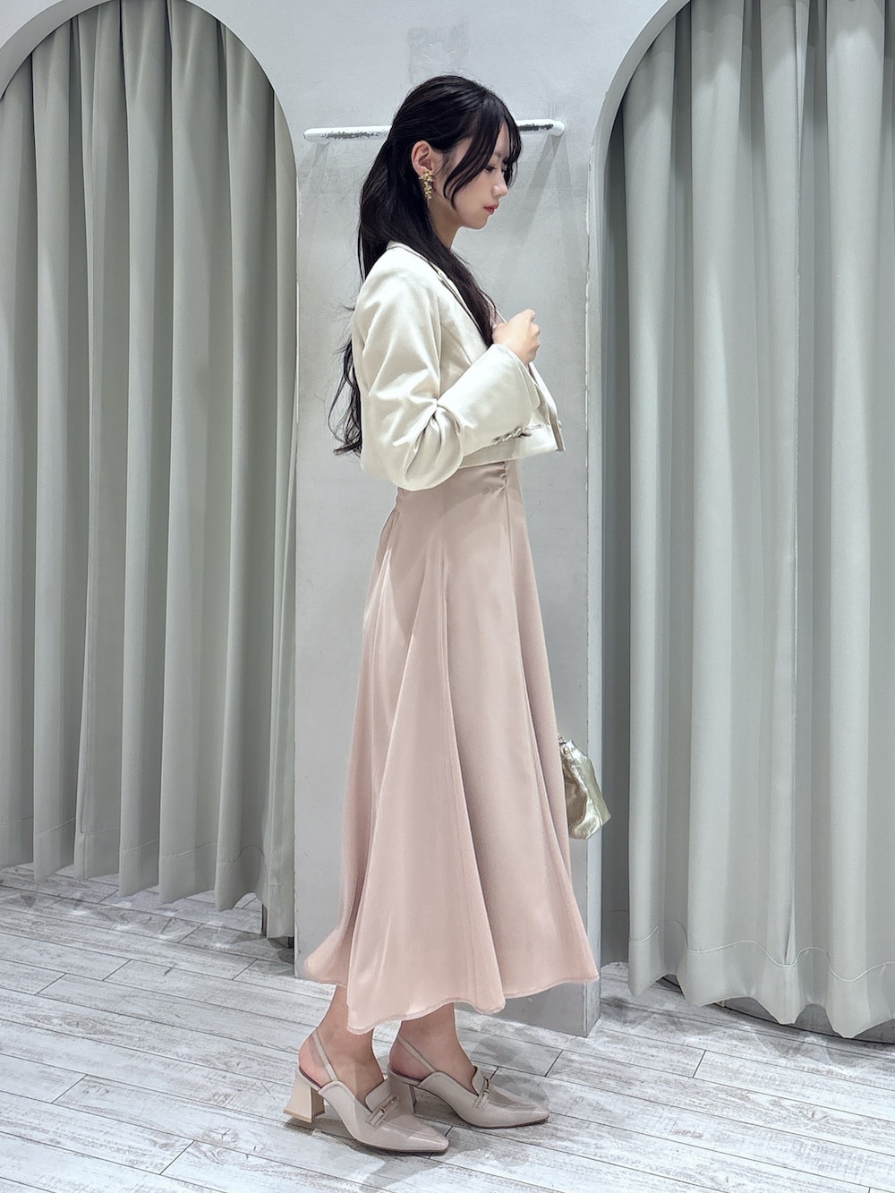 ピンク系のドレス、ホワイト系のテーラードジャケット、ゴールド系のショルダーバッグを着用したレディースの春コーディネートの3枚目の写真