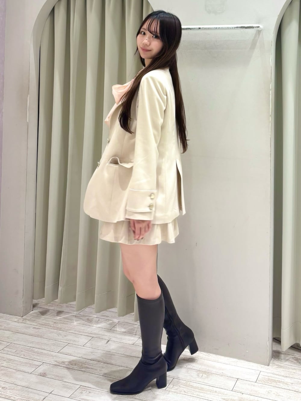 ピンク系のシャツ/ブラウス、ホワイト系のテーラードジャケット、ホワイト系のスカートを着用したレディースの冬コーディネートの2枚目の写真