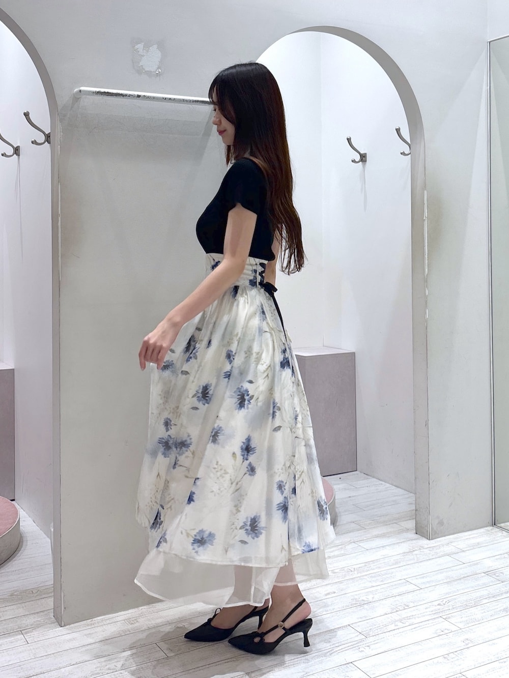 ブラック系のニット/セーター、ホワイト系のスカート、ブラック系のサンダルを着用したレディースの夏コーディネートの3枚目の写真