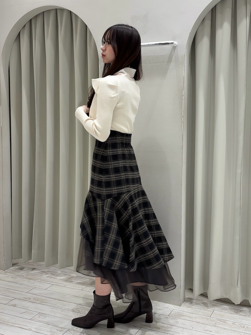 ホワイト系のニット/セーター、グレー系のスカート、ホワイト系のハンドバッグを着用したレディースの冬コーディネートの4枚目の写真
