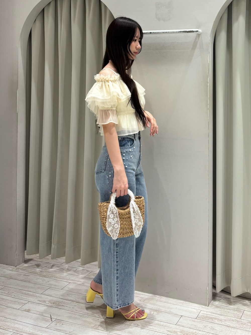 ホワイト系のシャツ/ブラウス、ブルー系のデニムパンツ、ベージュ系のハンドバッグを着用したレディースの夏コーディネートの3枚目の写真