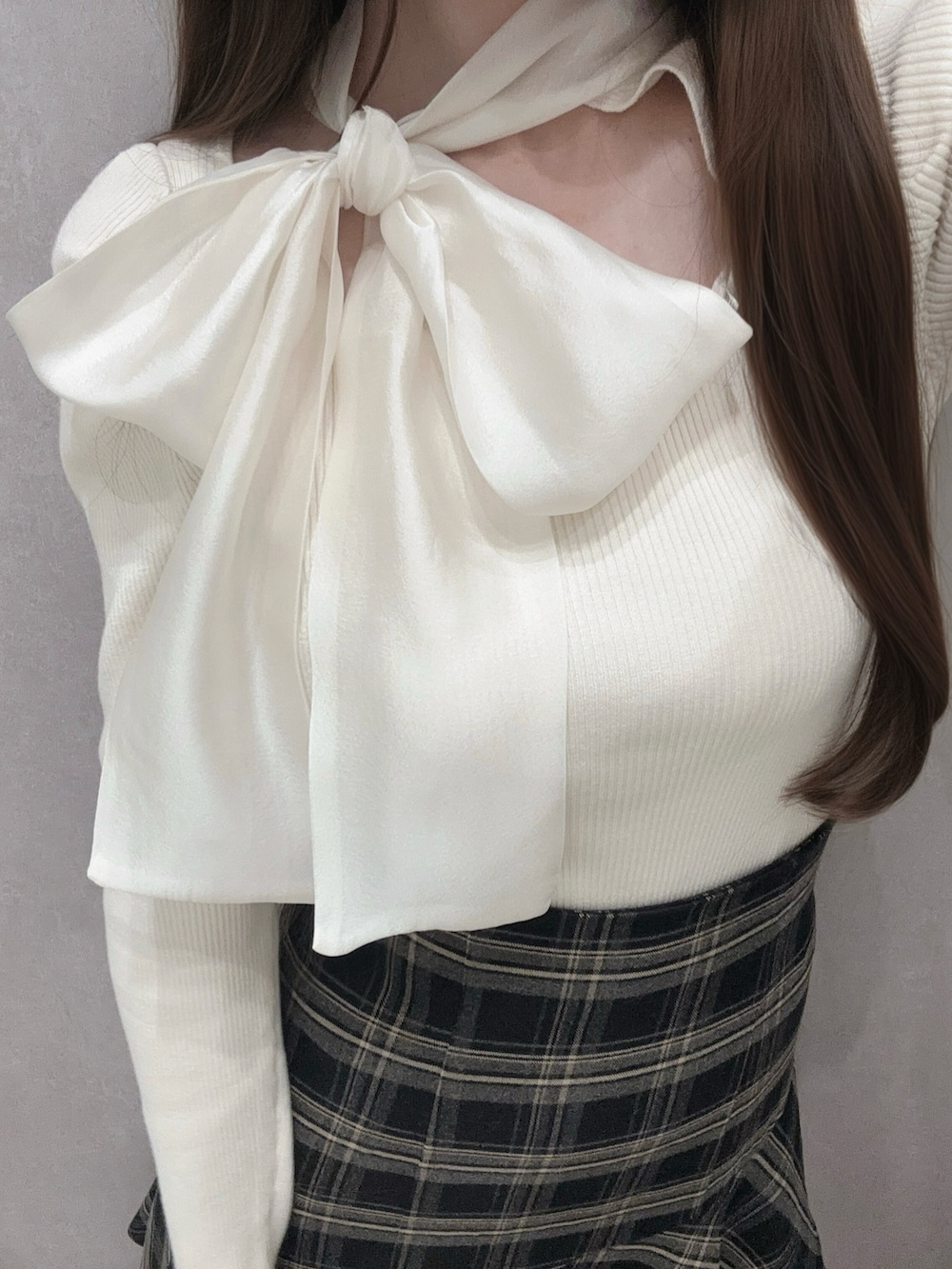 ホワイト系のニット/セーター、グレー系のスカート、ホワイト系のハンドバッグを着用したレディースの冬コーディネートの7枚目の写真