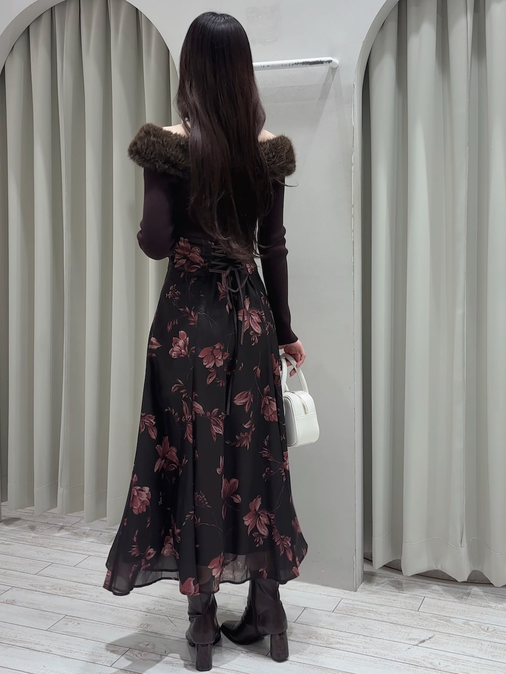 ブラウン系のワンピース、ホワイト系のハンドバッグ、ブラウン系のブーツを着用したレディースの冬コーディネートの7枚目の写真