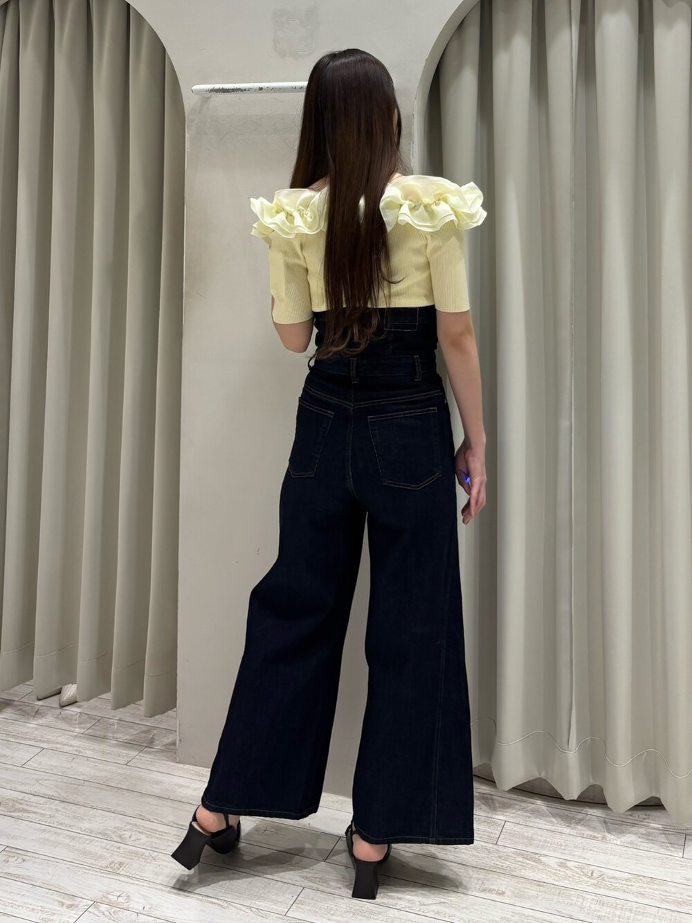 イエロー系のニット/セーター、ブルー系のその他パンツ、ブラウン系のパンプスを着用したレディースの春コーディネートの4枚目の写真