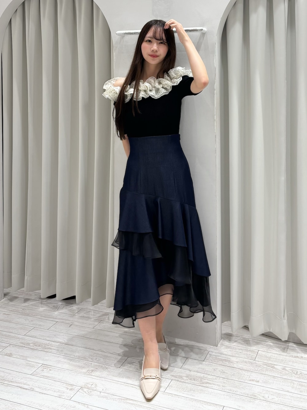 ブルー系のスカート、その他のニット/セーター、ホワイト系のパンプスを着用したレディースの春コーディネートの2枚目の写真