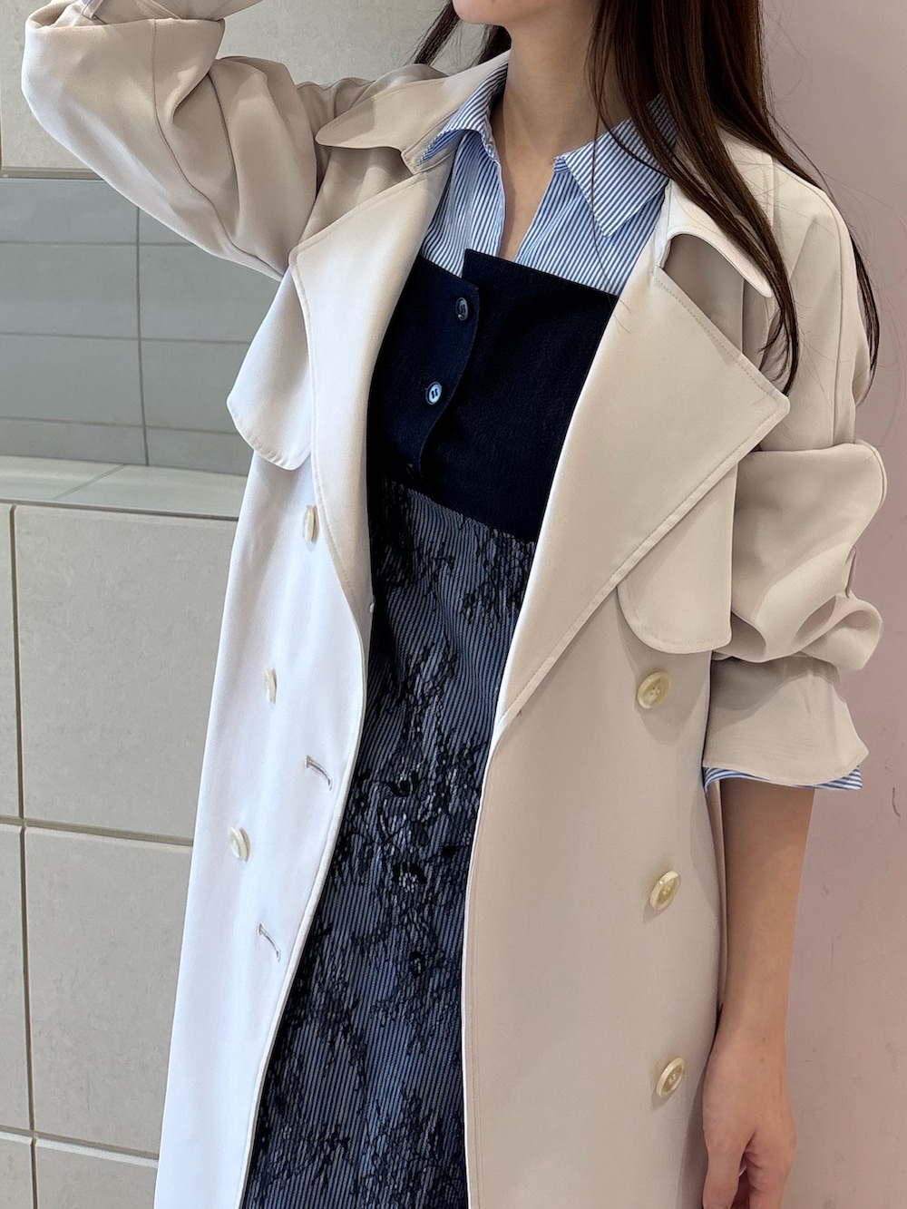 ブルー系のワンピース、ホワイト系のトレンチコート、ホワイト系のブーツを着用したレディースの冬コーディネートの7枚目の写真