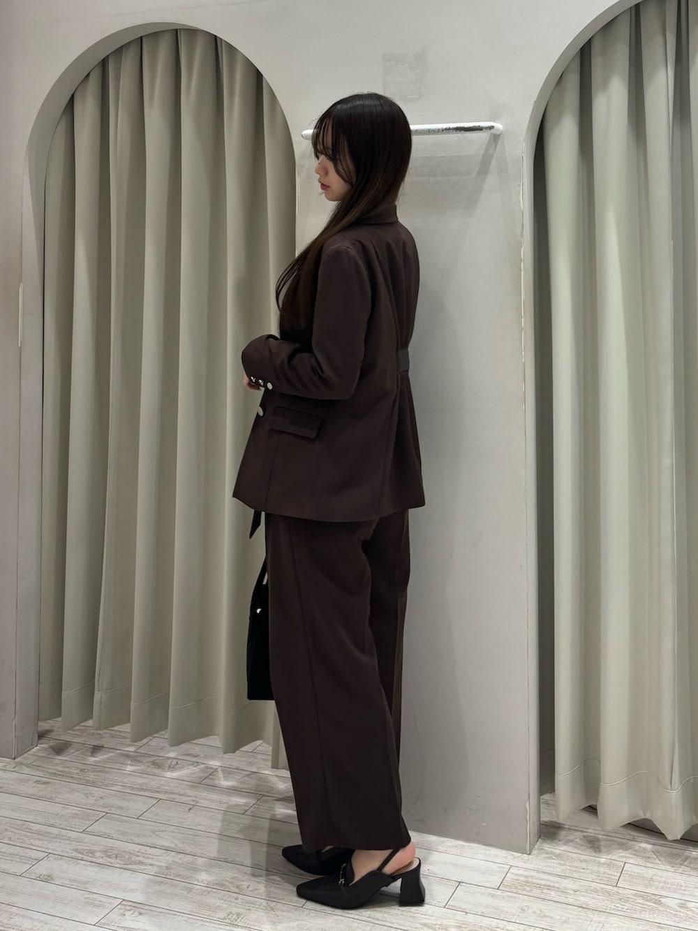 ブラウン系のテーラードジャケット、ホワイト系のニット/セーター、ブラウン系のその他パンツを着用したレディースの春コーディネートの3枚目の写真