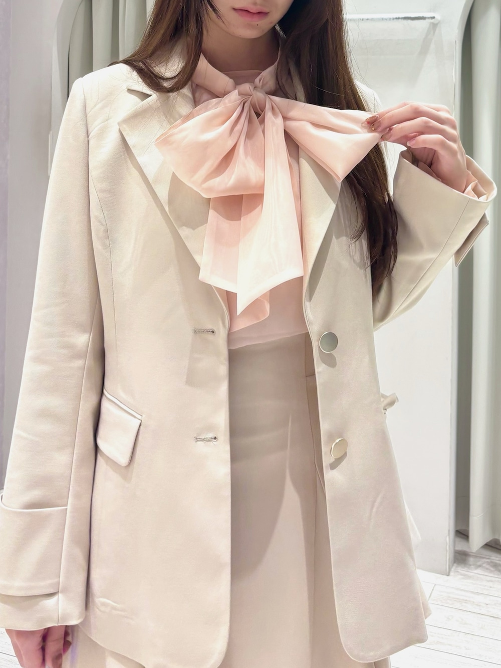 ピンク系のシャツ/ブラウス、ホワイト系のテーラードジャケット、ホワイト系のスカートを着用したレディースの冬コーディネートの6枚目の写真