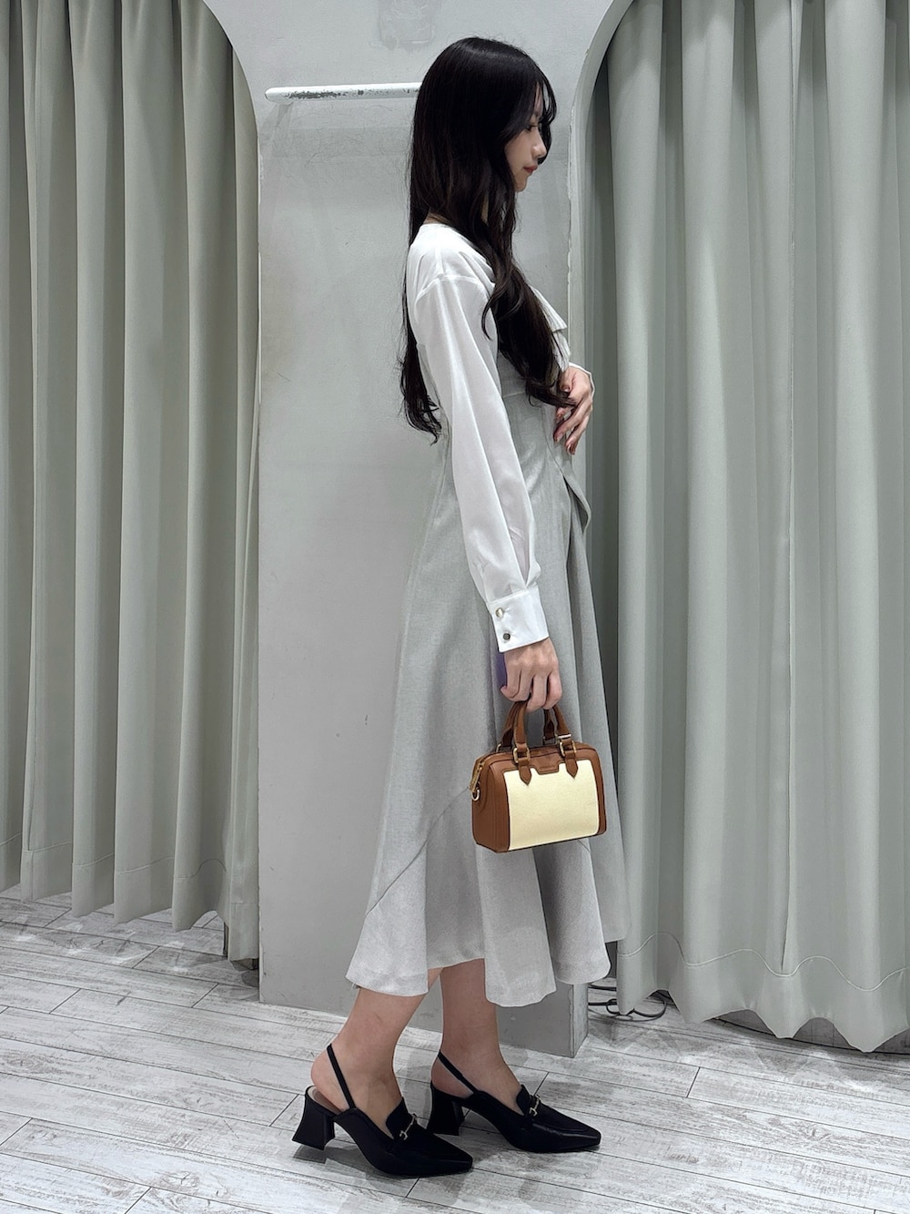 ベージュ系のワンピース、ブラウン系のハンドバッグ、ブラウン系のパンプスを着用したレディースの春コーディネートの5枚目の写真