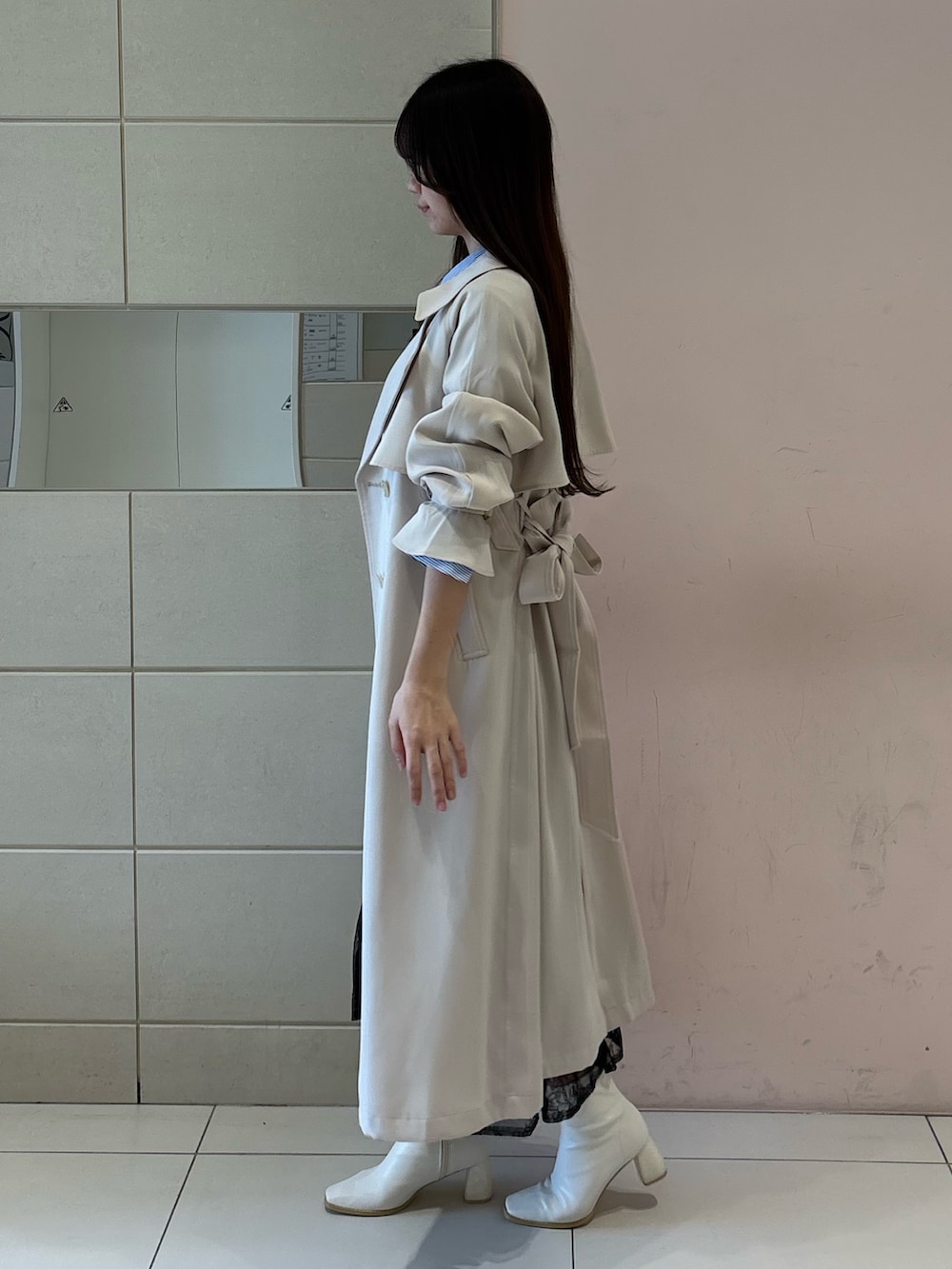 ブルー系のワンピース、ホワイト系のトレンチコート、ホワイト系のブーツを着用したレディースの冬コーディネートの6枚目の写真