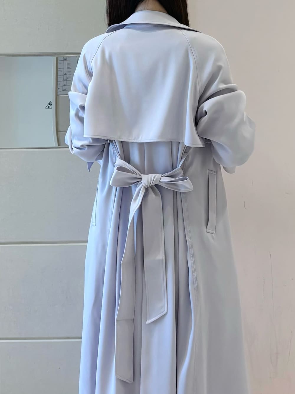 ホワイト系のワンピース、パープル系のトレンチコート、ホワイト系のブーツを着用したレディースの冬コーディネートの7枚目の写真