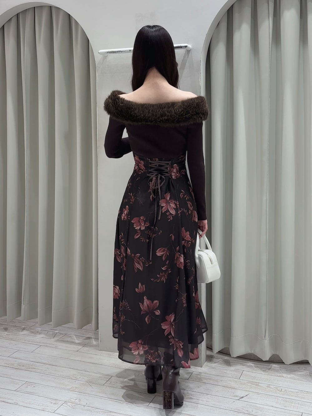 ブラウン系のワンピース、ホワイト系のハンドバッグ、ブラウン系のブーツを着用したレディースの冬コーディネートの8枚目の写真