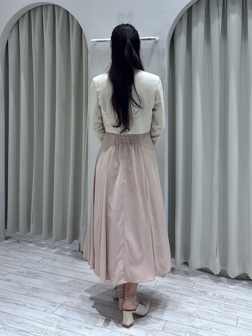 ピンク系のドレス、ホワイト系のテーラードジャケット、ゴールド系のショルダーバッグを着用したレディースの春コーディネートの4枚目の写真