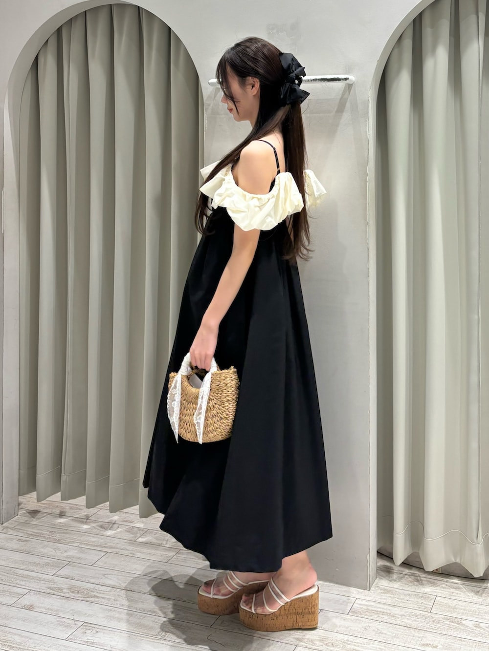 ブラック系のワンピース、ベージュ系のハンドバッグ、その他のサンダルを着用したレディースの夏コーディネートの3枚目の写真