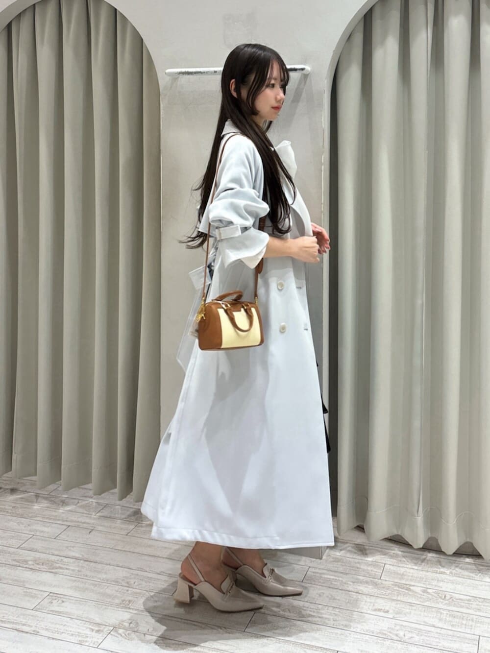 ホワイト系のパンプス、ホワイト系のシャツ/ブラウス、ブラウン系のハンドバッグを着用したレディースの春コーディネートの5枚目の写真