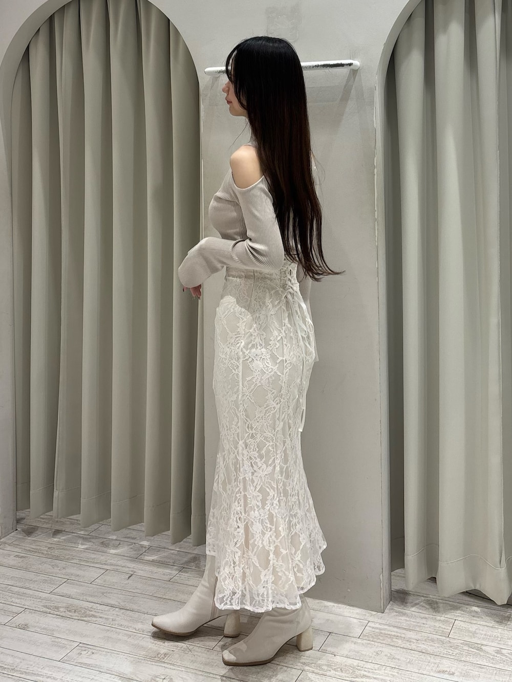 ベージュ系のニット/セーター、ホワイト系のスカート、ホワイト系のブーツを着用したレディースの春コーディネートの6枚目の写真