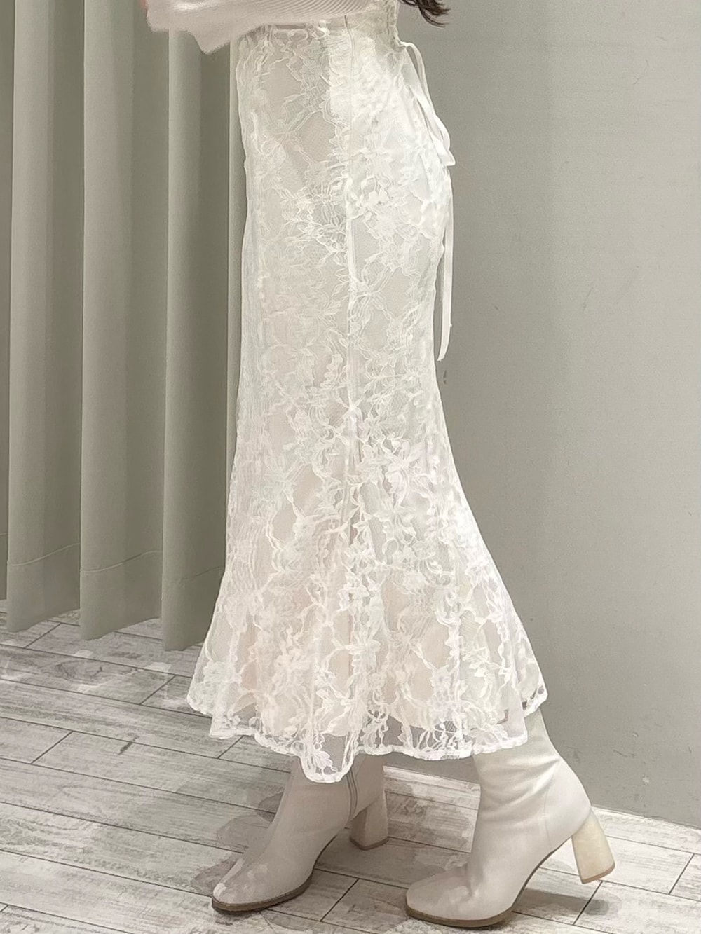 ベージュ系のニット/セーター、ホワイト系のスカート、ホワイト系のブーツを着用したレディースの春コーディネートの8枚目の写真