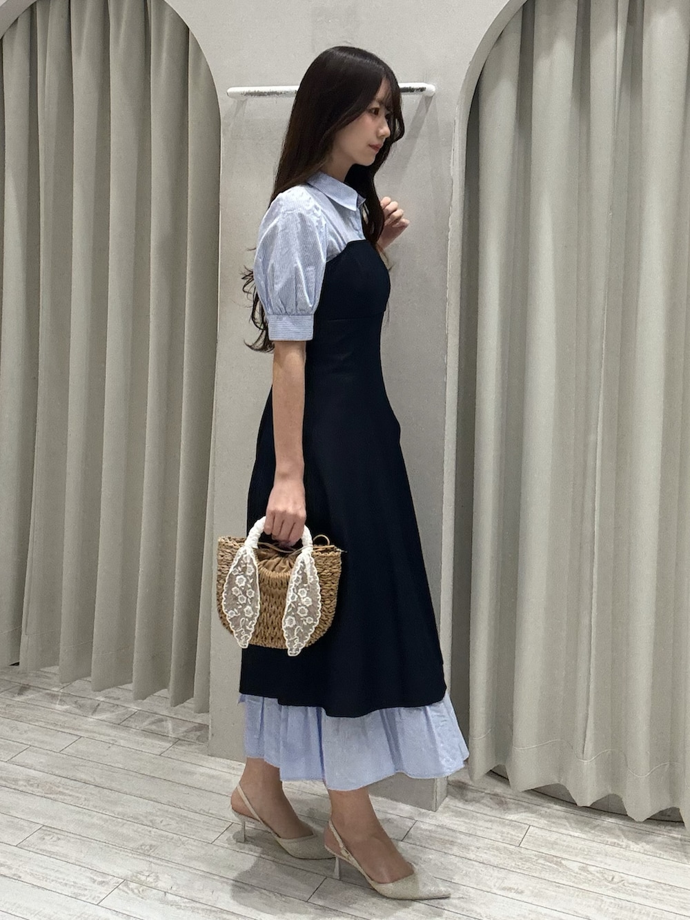 ブルー系のワンピース、ベージュ系のハンドバッグ、ホワイト系のパンプスを着用したレディースの春コーディネートの5枚目の写真